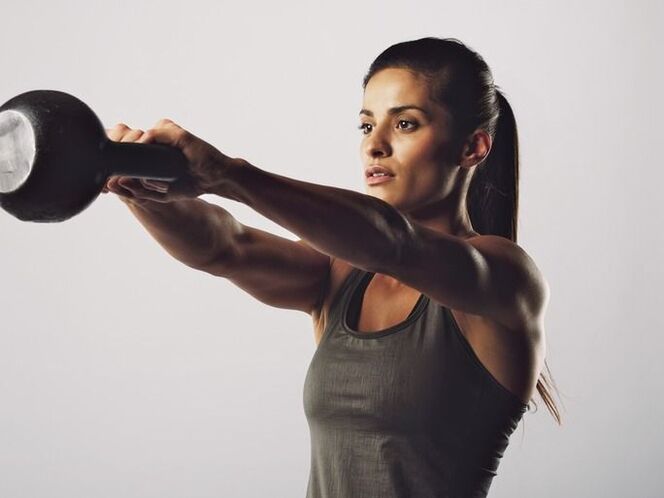 Una ragazza esegue un esercizio per ingrandire il seno usando un kettlebell